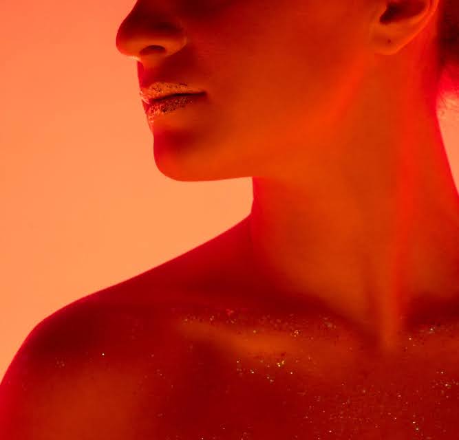 A woman undergoing red light therapy at home.